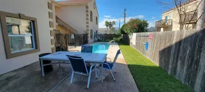 A bright outdoor space with a cozy patio table, pool access & palm‑lined surroundings offers guests a relaxed place to unwind. Clean walkways, sunny open areas & a welcoming coastal setting create an inviting spot for lounging and easy outdoor enjoy.
