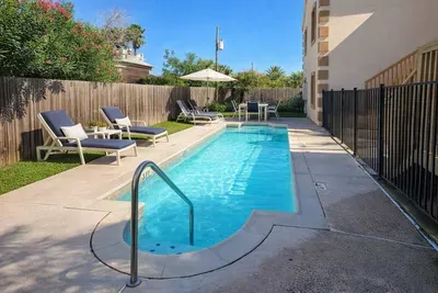 Relax by the sparkling Pool – Cozy Outdoor Retreat with Lounge Seating, Dining Area & Fenced Privacy Near Beach