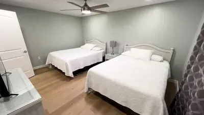 Unwind in this calming guest bedroom with two double beds, modern finishes and plush white linens. Perfect for friends or families, the spacious layout and serene décor provide a comfortable retreat for a restful island getaway.