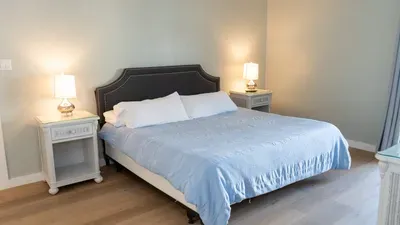 Rest easy in this serene bedroom featuring a plush comfy bed with soft linens, flanked by elegant bedside tables and ambient lighting. A peaceful haven designed for comfort and a restful night’s sleep after a day of island adventures.