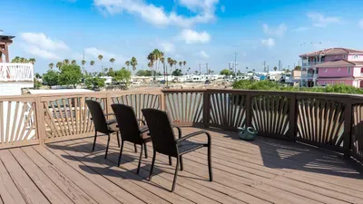 Sunny deck with comfortable seating and open views of palm trees and the surrounding coastal area. A peaceful spot to sip coffee, unwind, and enjoy the fresh breeze.