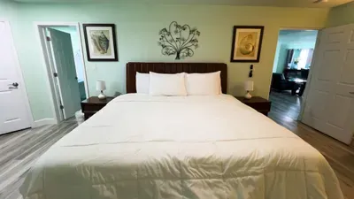 Calm & Coastal
Serene bedroom with soft green tones, plush bedding, ceiling fan, and natural light. Coastal accents and warm wood flooring create a peaceful retreat.