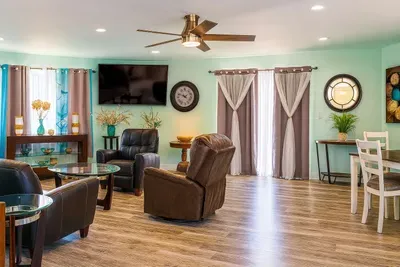 Spacious Mint-Green Living Room | Recliners, Smart TV, Natural Light, Dining Area, Stylish Decor
