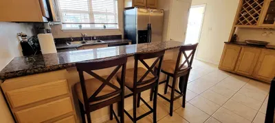 Enjoy a well‑organized kitchen with modern appliances, generous cabinetry, and a built‑in laundry nook. The warm palette, clean layout, and bar‑stool seating make this space perfect for meal prep, quick snacks, and effortless vacation living.