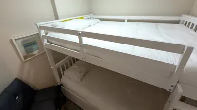Fun Bunk Bed Coastal Nook
Perfect for kids & friends sturdy white bunk bed with fresh linens, yellow accents on top cozy lower trundle. Seaside frame hangs nearby compact leather chair fits snugly. Ideal family add-on in soft-lit, beach-inspired room