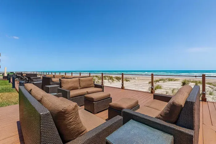 Oceanfront Deck with Plush Seating & Panoramic Views
Relax on a spacious beachfront deck with plush wicker seating, glass railing, and stunning ocean views. Perfect for morning coffee or sunset cocktails. Steps from the sand—ideal for families.