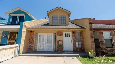 Warm, welcoming townhouse with a clean coastal feel, set along a quiet South Padre street. Soft tan tones, bright skies, and simple curb appeal create an easygoing first impression that sets the tone for a relaxed island stay.