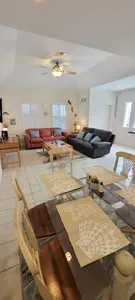Bright Open Living Space • Cozy Sofas, Glass Dining Table & Fully Equipped Kitchen • A Comfortable, Welcoming Area for Groups