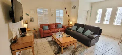 A bright, cozy living room with an easy, welcoming flow, where warm colors and simple décor create a relaxed, lived‑in feel. It’s a comfortable spot that naturally invites conversation, quiet downtime, and unhurried moments throughout your stay.