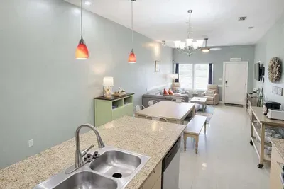 Modern Coastal Retreat: Open-Concept Living, Granite Kitchen Island, Cozy Dining Nook, Plush Sofa, Smart TV, Natural Light, Steps to Beach & Dining