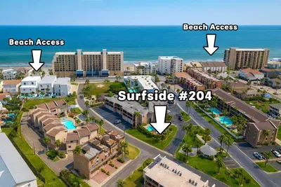 Surfside #204: Prime Beachfront Condo w/ Multiple Access Points & Pool. Aerial panorama reveals Surfside #204 nestled amid Gulf high-rises, sparkling community pool, palm accents & direct beach access paths on three sides.