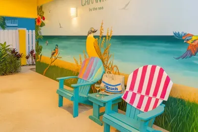 Enjoy the vibrant outdoor shower lounge at Canary by the Sea, featuring playful murals, aqua Adirondack chairs, and beachy décor. This fun, shaded spot is ideal for rinsing off or unwinding after a day in the sun and surf.