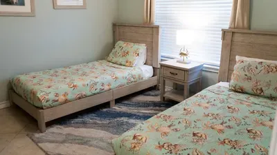 Twin Coastal Beds
Sea glass Dream Retreat for Two. Twin driftwood frames w/ floral bedding, wave rug & shell lamp glow in seafoam serenity. Nautical frames add charm—cozy haven for kids or guests to recharge amid beach vibes!