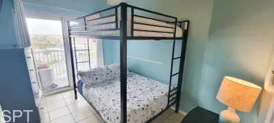 Bright Bunk Room with Balcony Access
Cozy bedroom with a full‑size bottom bunk, twin top bunk, light blue walls, and a sliding door to the balcony—perfect for families or groups needing comfort and space.