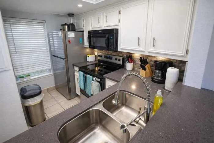 Modern Kitchen with Stainless Steel Appliances, Coffee Station, and Bright Natural Light – Perfect for Short-Term Stays