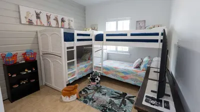 Bright, kid‑friendly bunk room featuring two cozy bunk beds with colorful bedding, playful décor & organized storage. Soft natural light, a roomy rug, & entertainment essentials create a fun, comfortable space perfect for families traveling together.