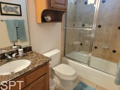 Cozy, well‑designed bathroom featuring a granite vanity, glass‑door tub, coordinated décor, and thoughtful essentials—creating a warm, polished space ideal for refreshing after outings and adding comfort throughout your stay.