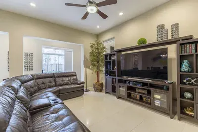 Spacious Living Room • Large Leather Sectional, Smart TV & Stylish Built‑Ins • Perfect for Movie Nights and Relaxing Island Stays