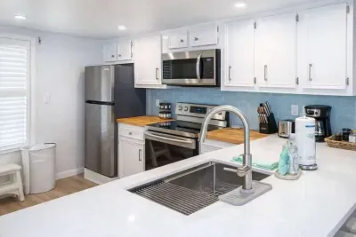 Bright, modern kitchen with stainless steel appliances, butcher block counters, subway tile backsplash, and natural light—perfect for cooking and entertaining in a clean, stylish space.