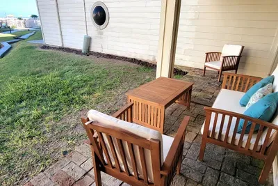 Outdoor Patio Retreat • Cozy Seating, Blue Accents & Peaceful Lawn Views • Perfect Spot to Relax After Beach & Island Adventures