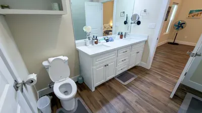 Sleek Spa-Style Bathroom
White double vanity, clean lines, ample storage & adjacent bedroom views! Fan, toiletries ready at 114 Pike St Unit A, SPI. Luxe comfort steps from beach access paradise. Refresh & relax!