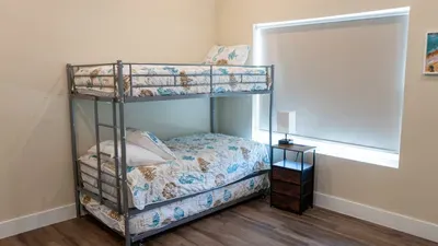 Adventure Bunk Bed Beach Nook
Sturdy metal bunks w/ seashell quilts & lamp—perfect kids' hideaway! Beach art, blinds for dreamy sleeps at 114 Pike St Unit A, SPI. Steps to ocean fun & direct access. Family beach dreams!