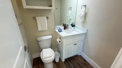 Crisp Coastal Half Bathroom
Spotless white vanity, mirror, towels & amenities—simple elegance! Wood floors at 114 Pike St Unit A, SPI. Freshen up quick before beach access adventures. Clean & comfy retreat!