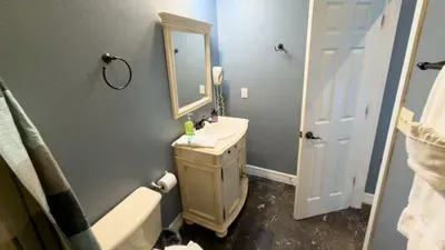 Bright Second Bathroom Retreat
Refresh in the charming bath with antique-style vanity, framed mirror, wall-mounted hair dryer, and soft blue walls. Essentials are ready with soap, towels, and shower curtain beside the toilet.