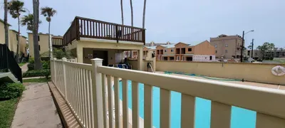 Resort‑style pool retreat featuring a sparkling swimming pool, elevated deck, and shaded lounge area perfect for relaxing under sunny coastal skies. Surrounded by palms and open views, it offers a breezy, laid‑back setting ideal for fun vacation.