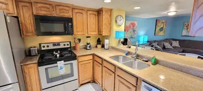 Warm, open‑concept kitchen & living space featuring stainless‑steel appliances, ample counter seating & cheerful coastal accents. Enjoy a comfy sectional, vibrant décor & seamless flow between rooms perfect for relaxed effortless South Padre vacation