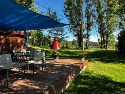 Shaded deck, outdoor fireplace, nature views.
