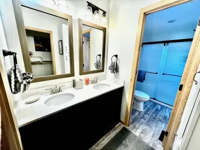 Inviting full bathroom featuring a double sink, stylish mirrors, and a clean, contemporary design.