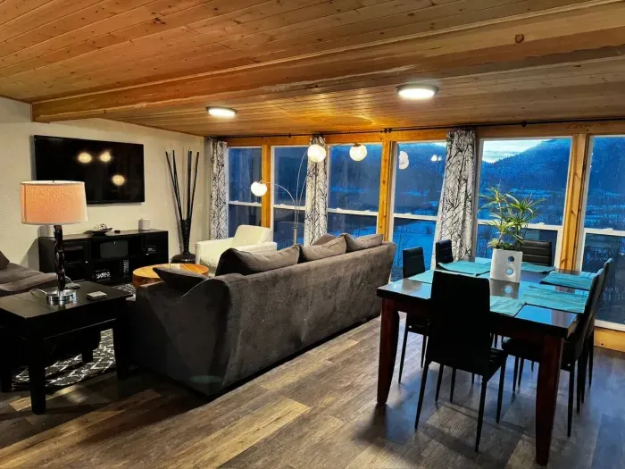 Spacious Airbnb living room with a view! Comfy seating & dining space. Perfect for groups. #AirbnbViews #CozyStay 