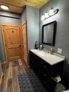 Modern light, framed mirror, gray textured walls.