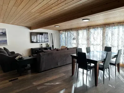 Comfortable sofa, TV, and dining table in a bright living area.