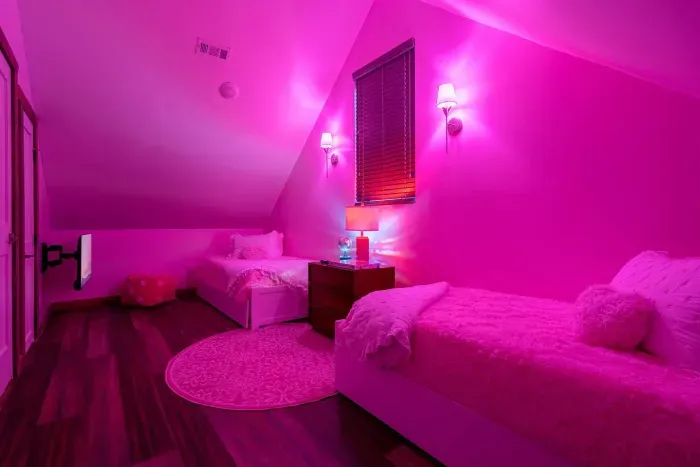 Tandem twin beds, pink lighting, and all the cozy cowgirl charm you could dream up.
