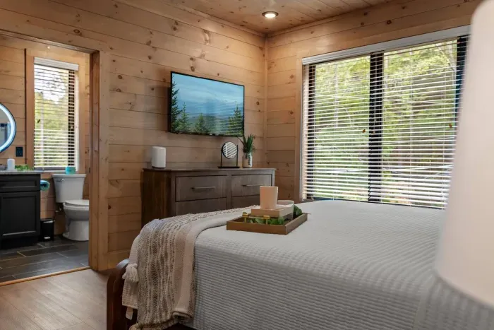 Rest comfortably in this inviting bedroom featuring warm wood tones, a plush king bed, and your own private full bath for added comfort and convenience.