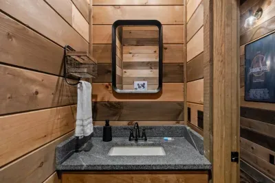 This convenient half bath is located in the downstairs hallway, right where all the fun happens. Perfect for quick access from the pool room, theater, and game areas.