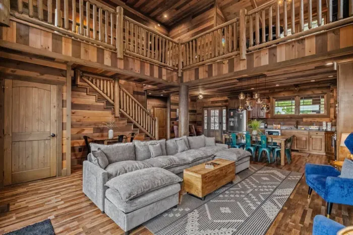 Open-concept living at its best. A spacious kitchen flows seamlessly into the living room, anchored by a large, cloud-like couch you’ll never want to leave.