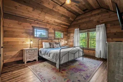 Bedroom 3 (king bed) is upstairs and  features a private full bathroom, a large open layout, a closet for storage, and a flat-screen TV for entertainment.