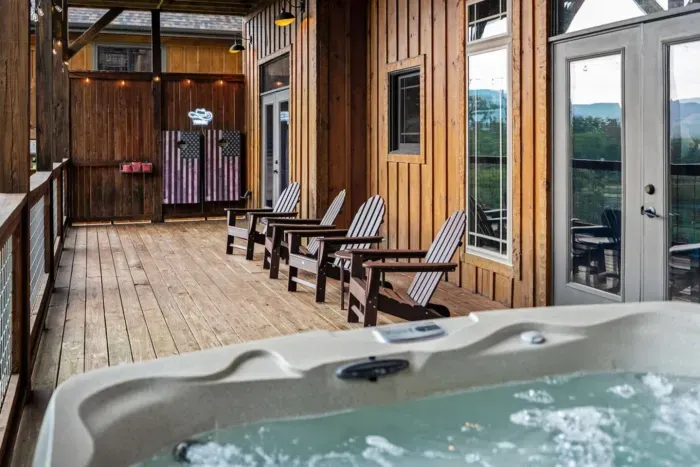 The bottom deck offers the best of both worlds—soak in the hot tub or challenge your friends to cornhole. Comfortable seating and sweeping views make it a favorite gathering spot.