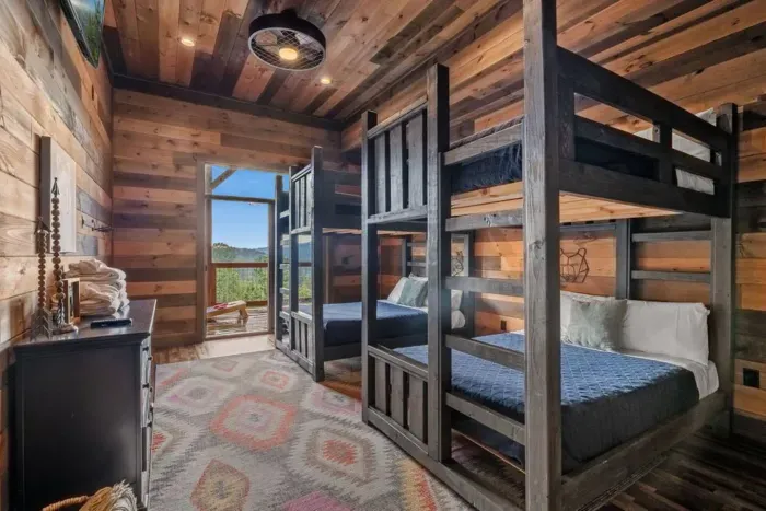 The downstairs double bunk room is the ultimate hangout for kids, featuring two bunk beds, a TV, and direct access outside. Just steps away, they’ll find the pool room and theater room, making this level a hub of fun.
