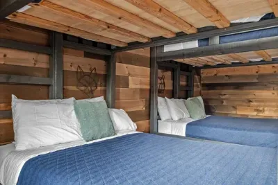 Perfect for families, this downstairs bunk room offers plenty of sleeping space with double bunks and its own TV. With easy access to the outdoor area, pool room, and theater room, it’s designed for entertainment and convenience.