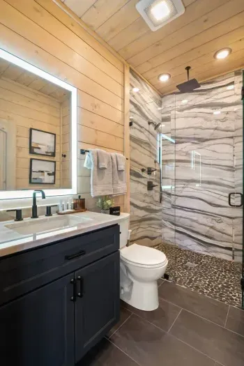 An upstairs bathroom with a queen bedroom, is stocked with everything you need for a comfortable stay. It features a shower, plush towels, and thoughtful amenities like shampoo, conditioner, body wash, lotion, tampons, cotton pads, and Q-tips.