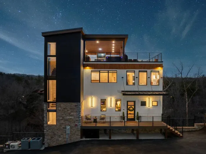 Maverick’s Lookout glows softly against the mountain backdrop—its elevated design and warm lights creating a dreamy presence in the trees. By night, it feels like a hidden retreat touched by magic, high above the world below.