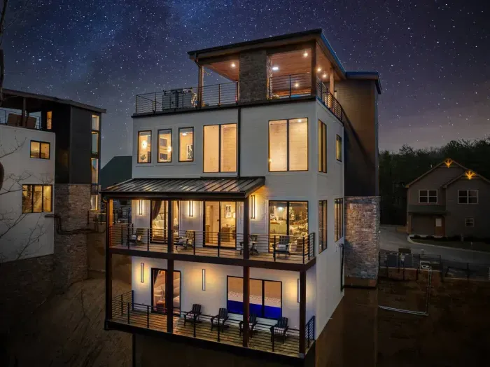 Maverick’s Lookout glows like a dream in the mountains—its elevated exterior lit softly against the night sky, casting warmth and magic over the trees below.
