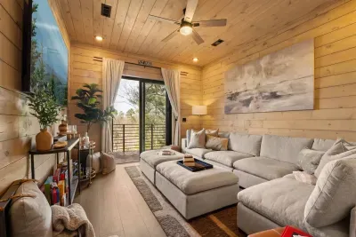 Downstairs, a cozy TV room invites you to unwind with soft seating, games, and a relaxed vibe perfect for movie nights or family time. This space also opens to a second private balcony—quiet, secluded, and surrounded by nature.