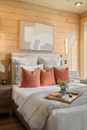 This bedroom features a cozy queen bed upgraded with a plush foam topper for extra comfort. A floor-length mirror adds both style and function, while soft textures and thoughtful touches create a restful, luxurious retreat.