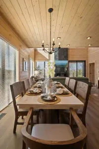 The modern kitchen table seats eight comfortably and sits at the heart of the space—perfect for meals, games, or catching up. Positioned within the kitchen, it offers a view of the living room TV, keeping everyone connected and part of the action.