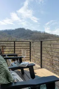 The main level balcony is a peaceful, scenic space accessible from both the living room and master bedroom. It features 4 comfortable chairs, perfect for sipping coffee, enjoying conversations, or simply soaking in the serene, natural surroundings.